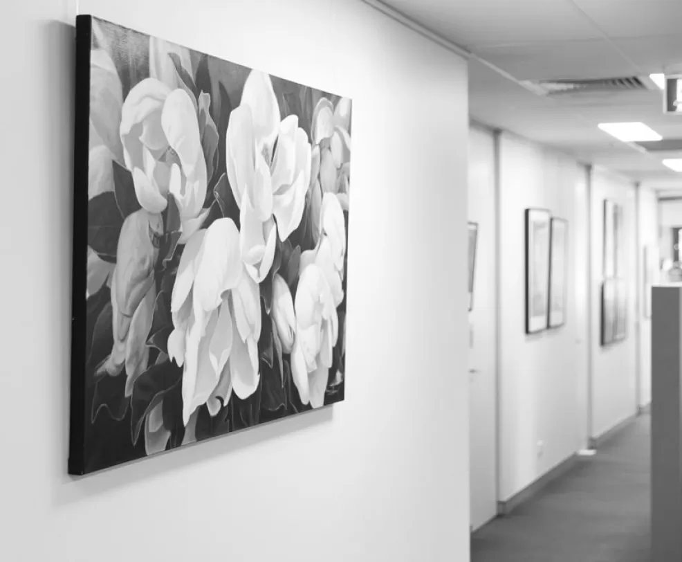 A framed floral artwork on the wall of a corridor at the practice