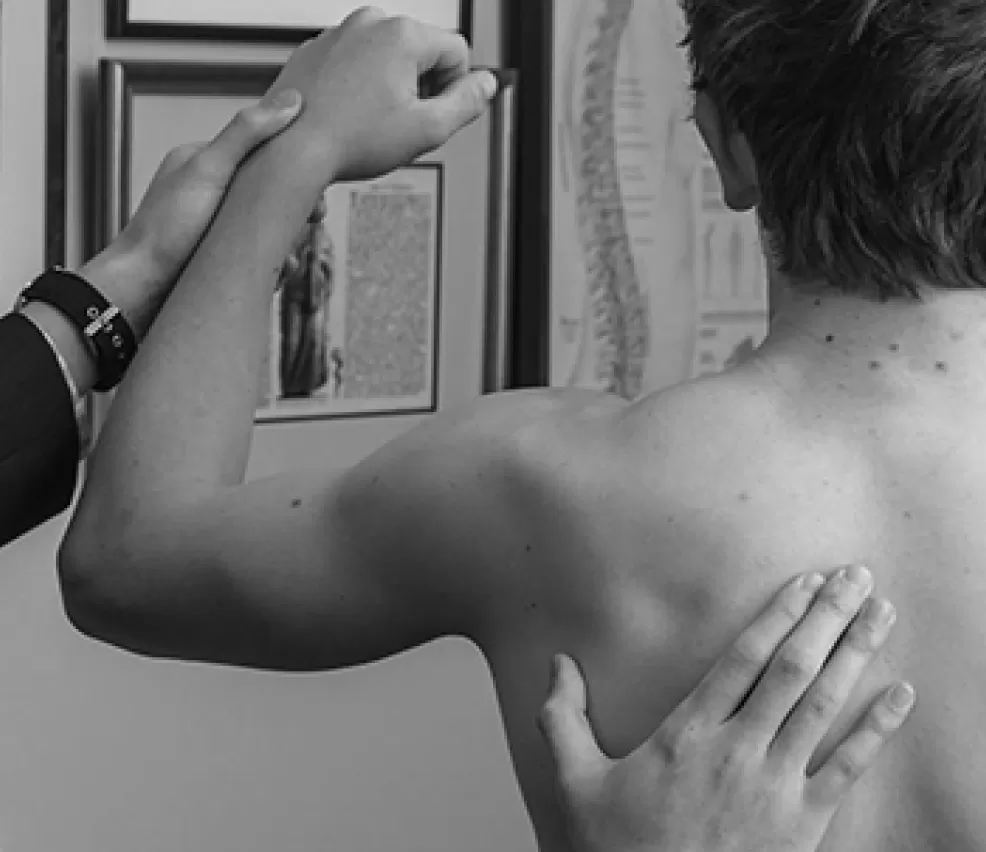 A clinician assessing the movement of a patient's shoulder