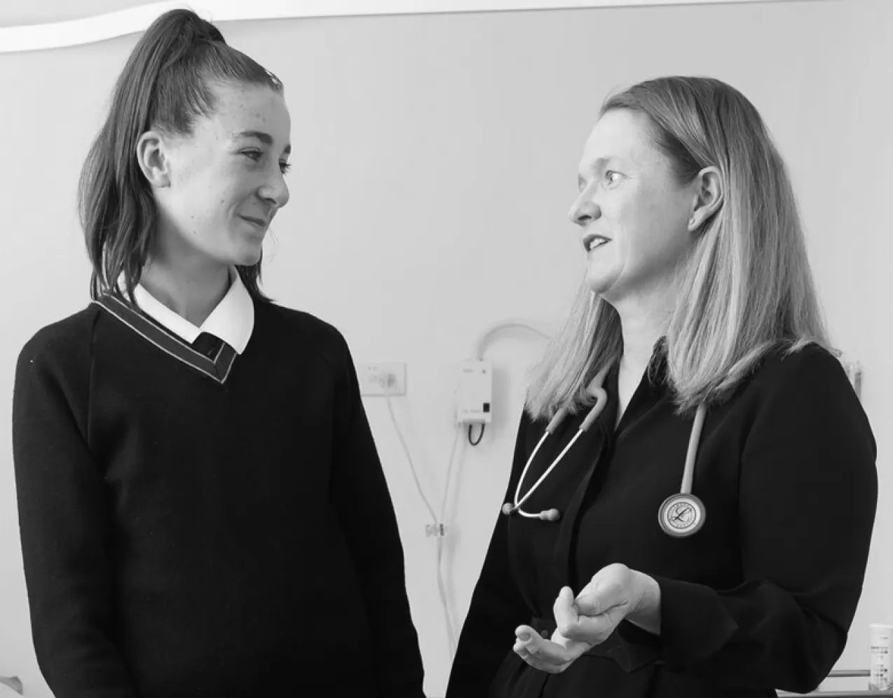 A doctor in conversation with a young patient in a consulting room