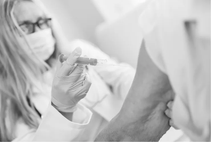 A clinician preparing a vaccination for a patient's upper arm