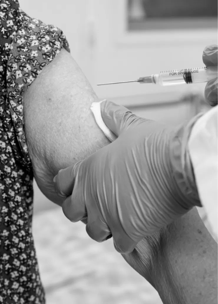 A clinician giving a patient a vaccination in the upper arm