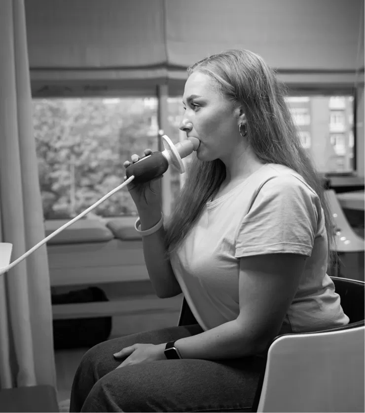 A patient blowing into a spirometer during a lung function test