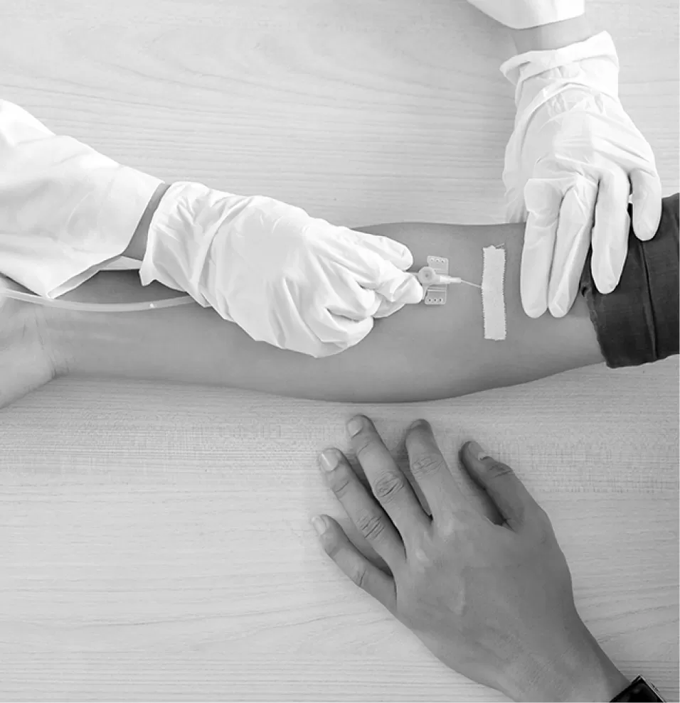 A practice nurse setting up an infusion for a seated patient