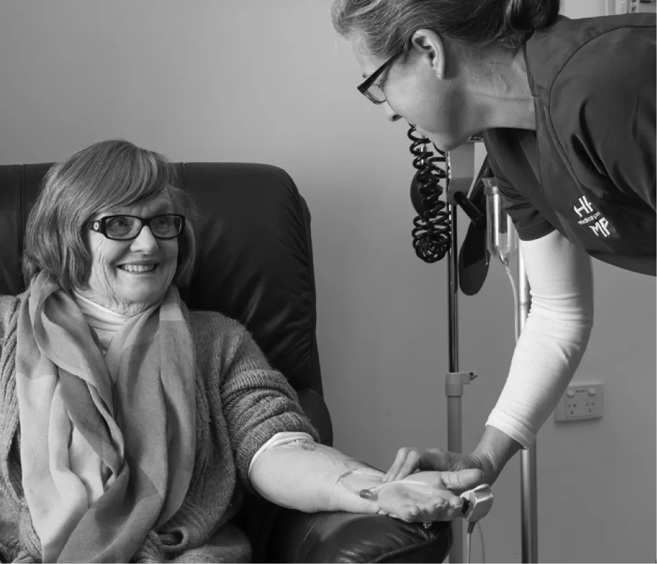 A gloved clinician applying a dressing to a patient's forearm