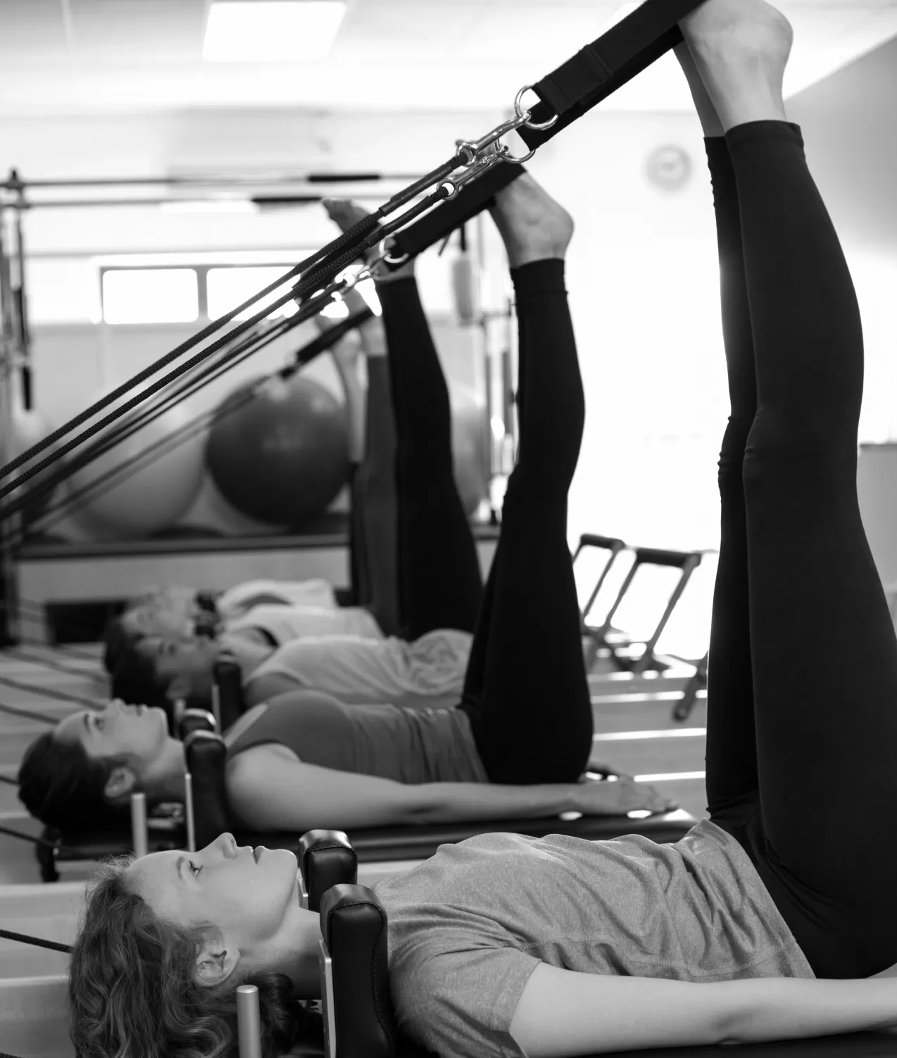 A group taking a clinical Pilates class on reformer machines