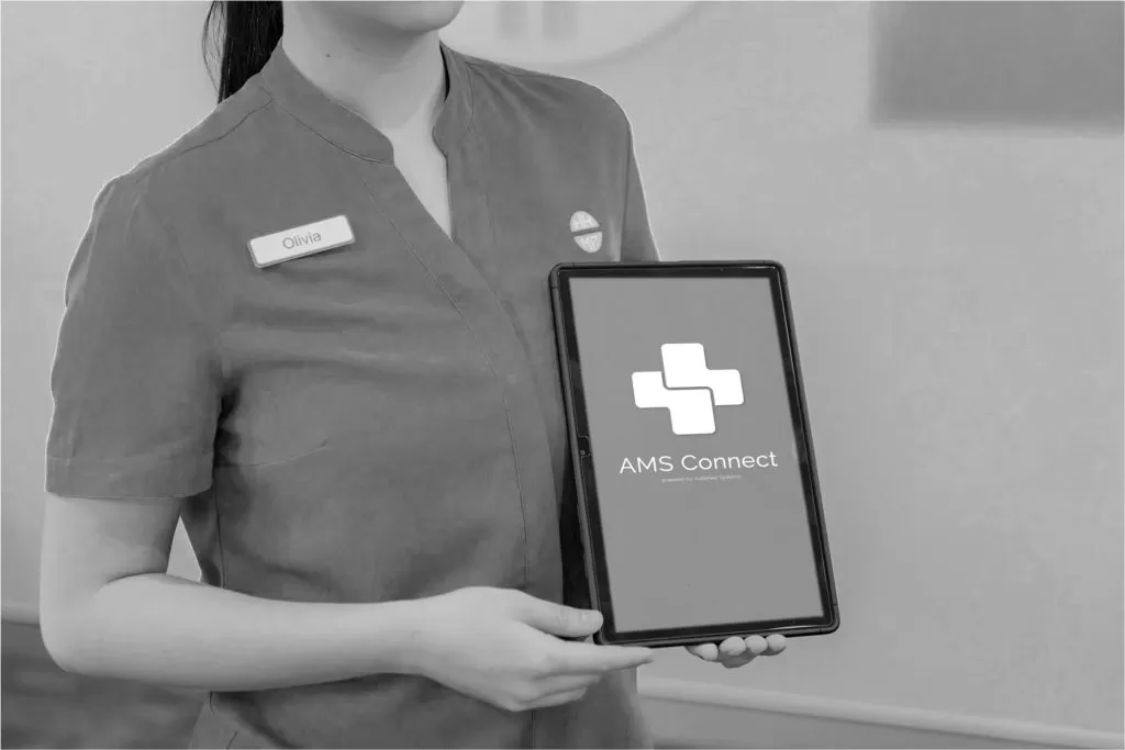 A staff member holding a tablet showing the AMS Connect app