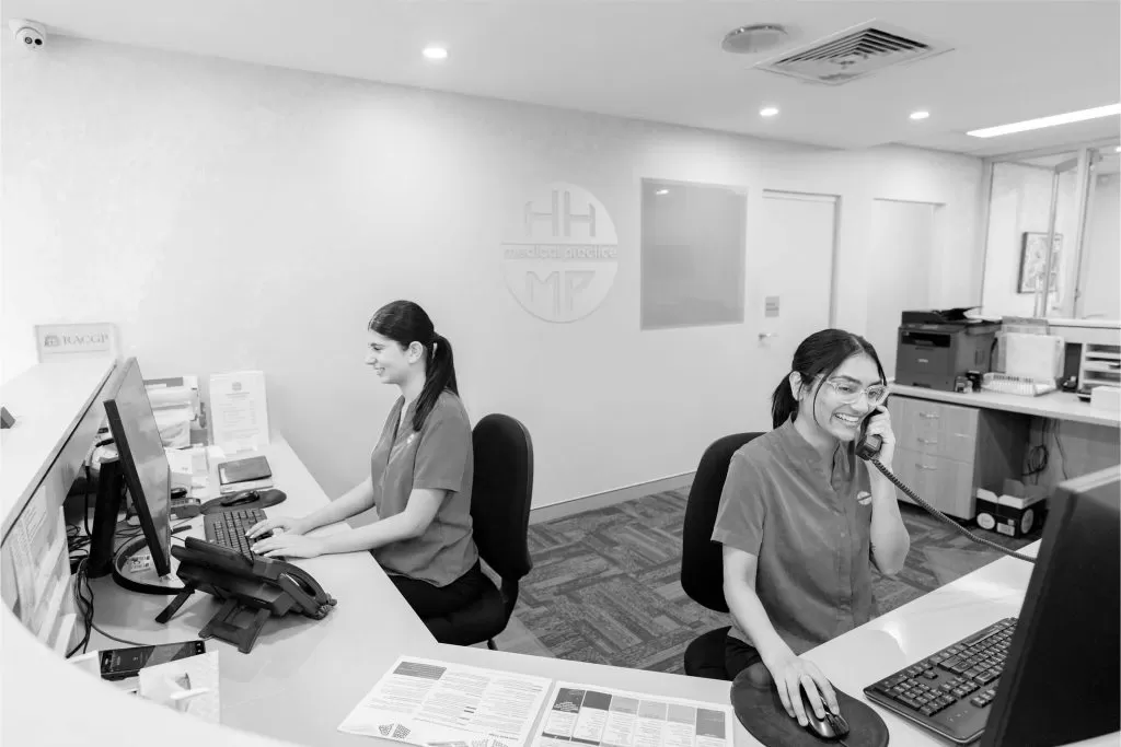 Two receptionists working at the practice front desk