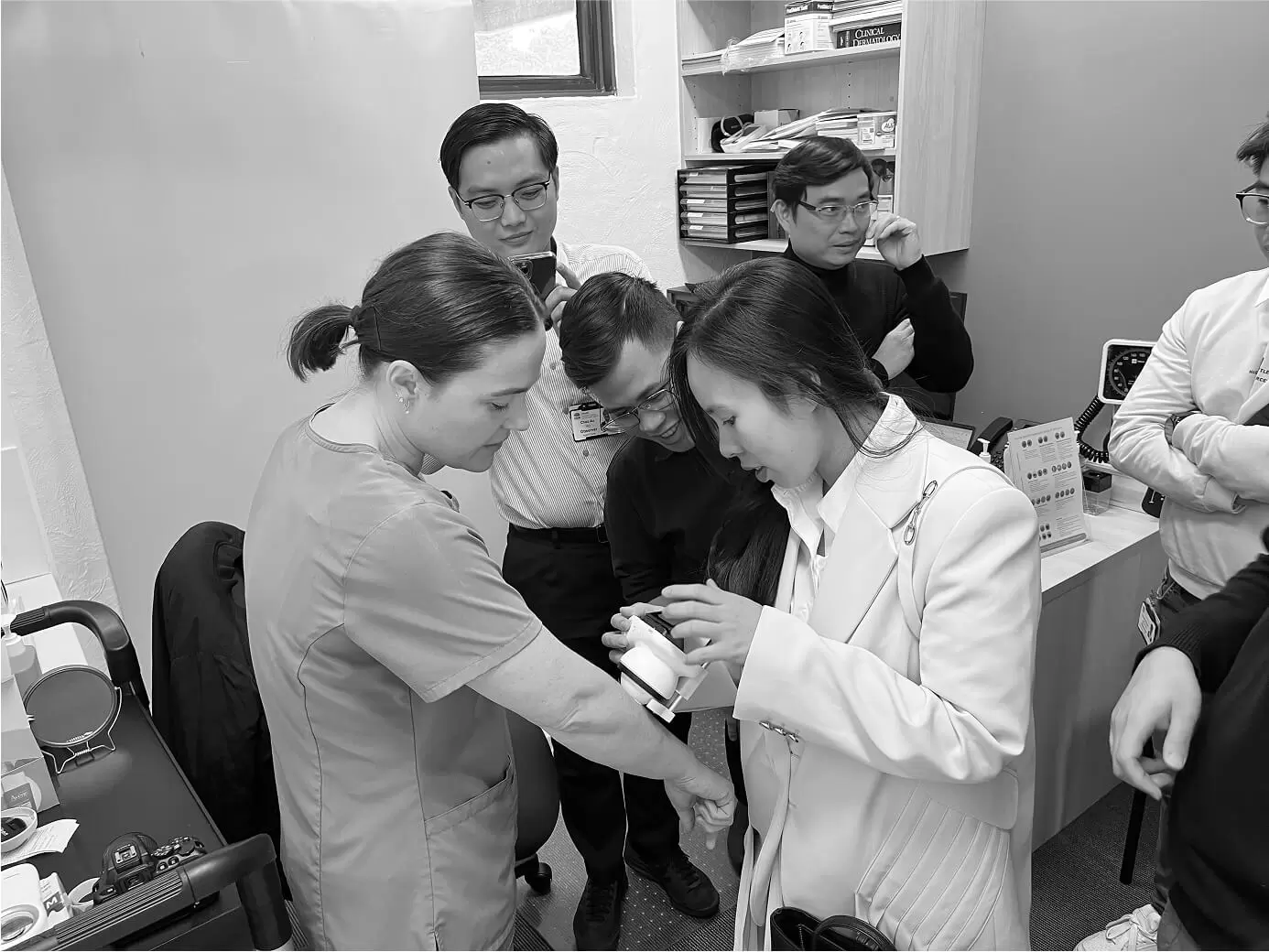 Trainees gathered around a clinician during a hands-on workshop