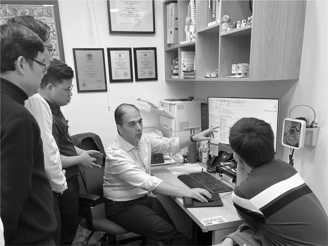 Trainees observing a clinician at a workstation during a teaching session