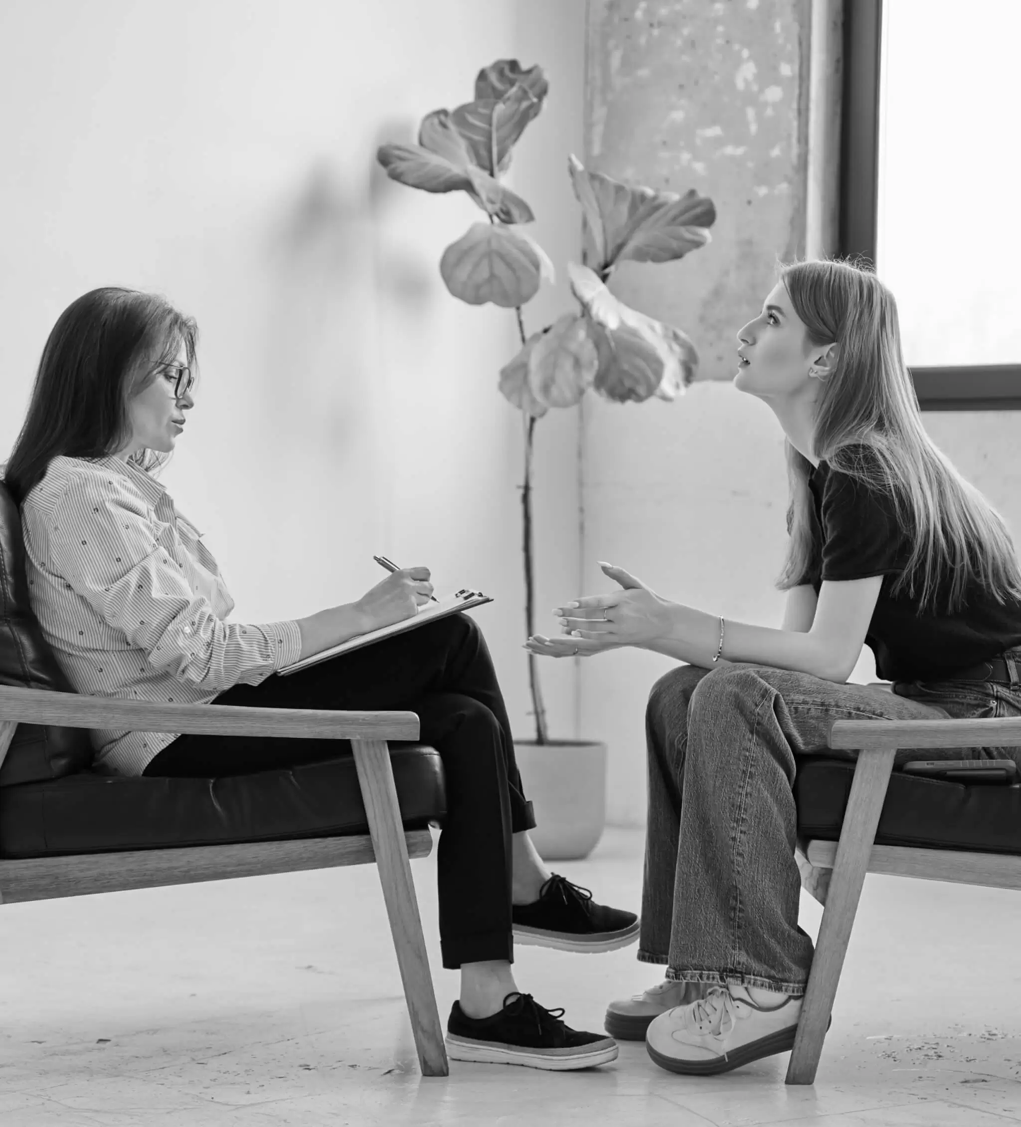 Two people talking in armchairs during a mental health consultation