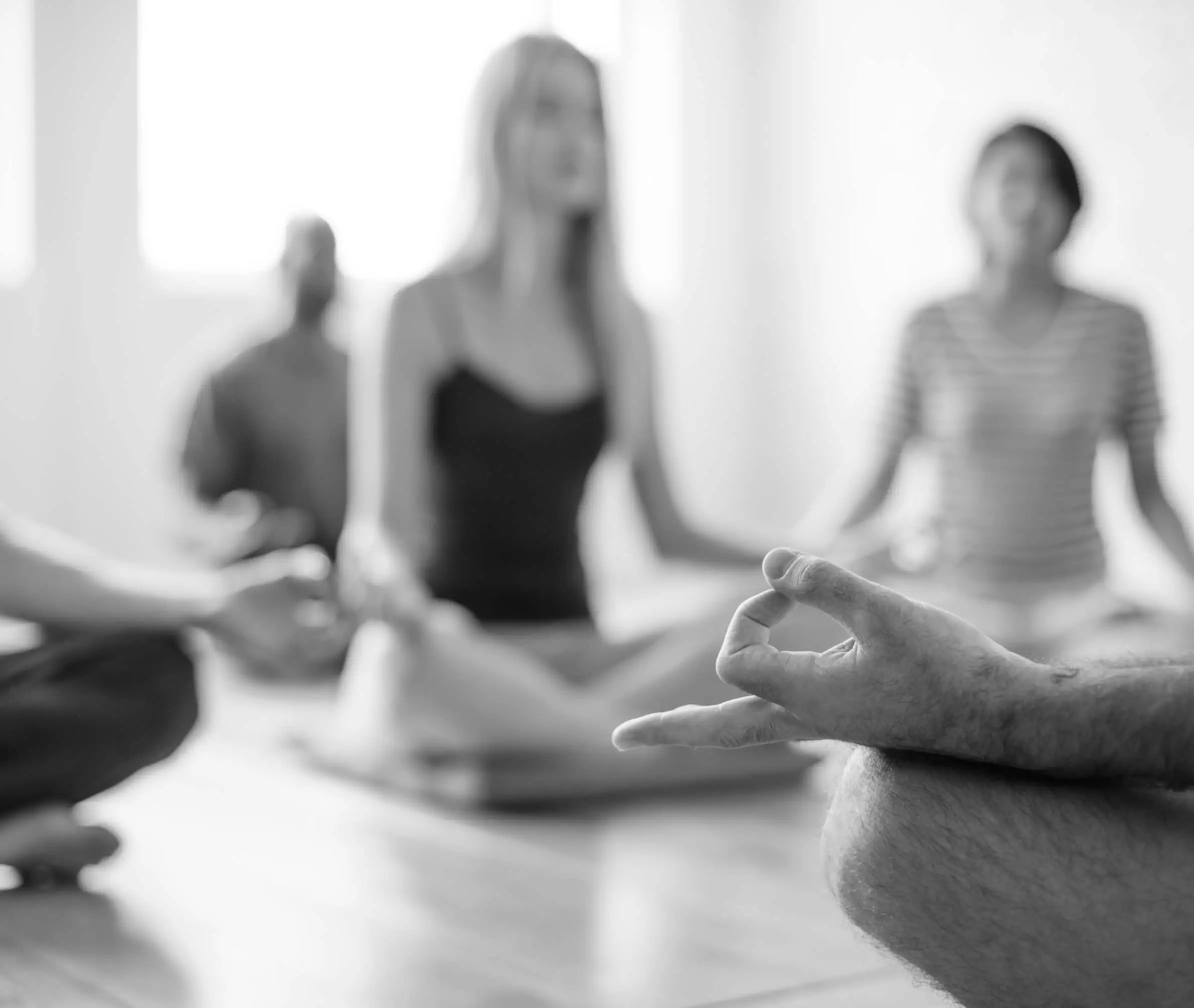 A group sitting cross legged in a meditation class