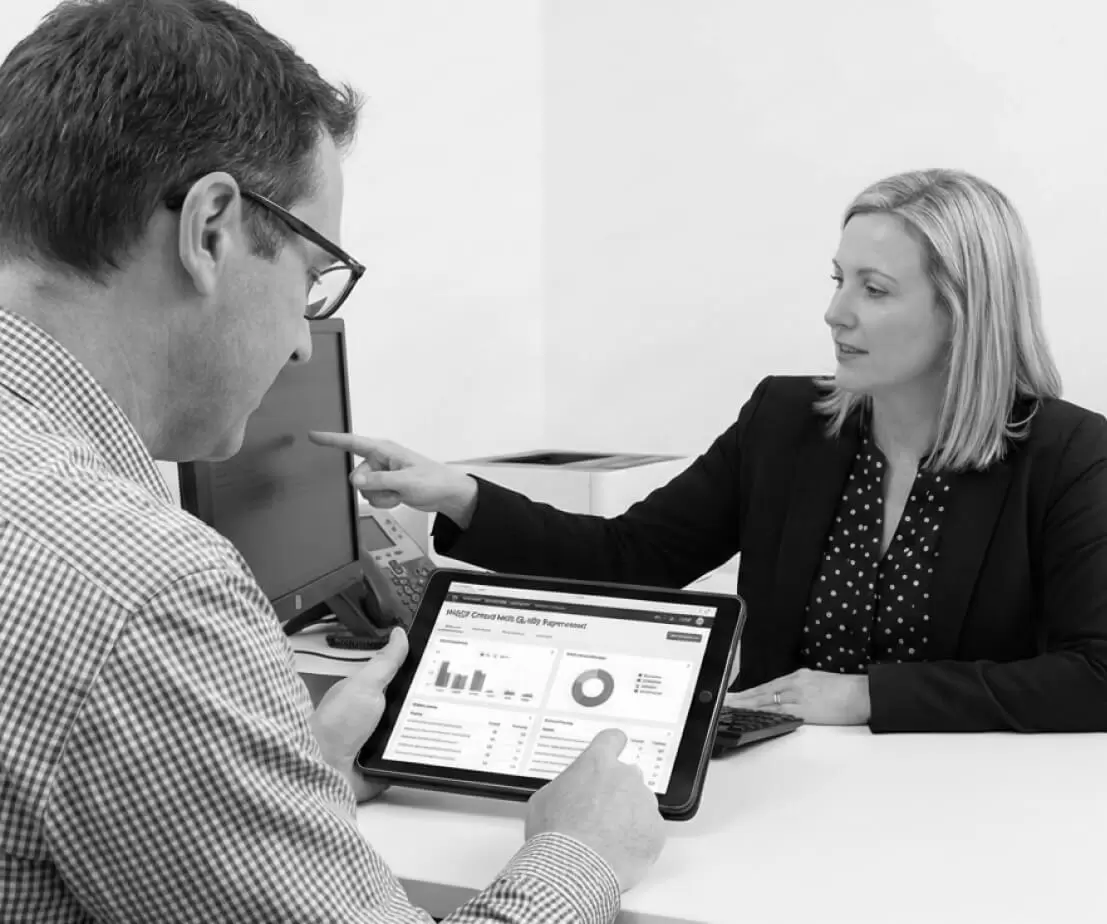 Two colleagues reviewing audit data on a tablet