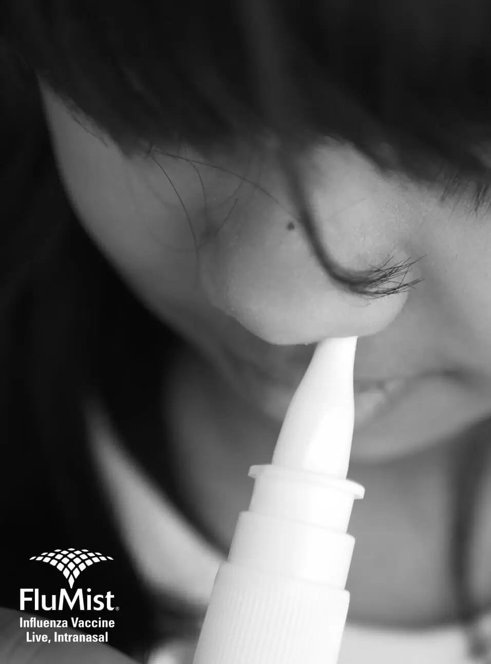 A person using a FluMist nasal spray influenza vaccine