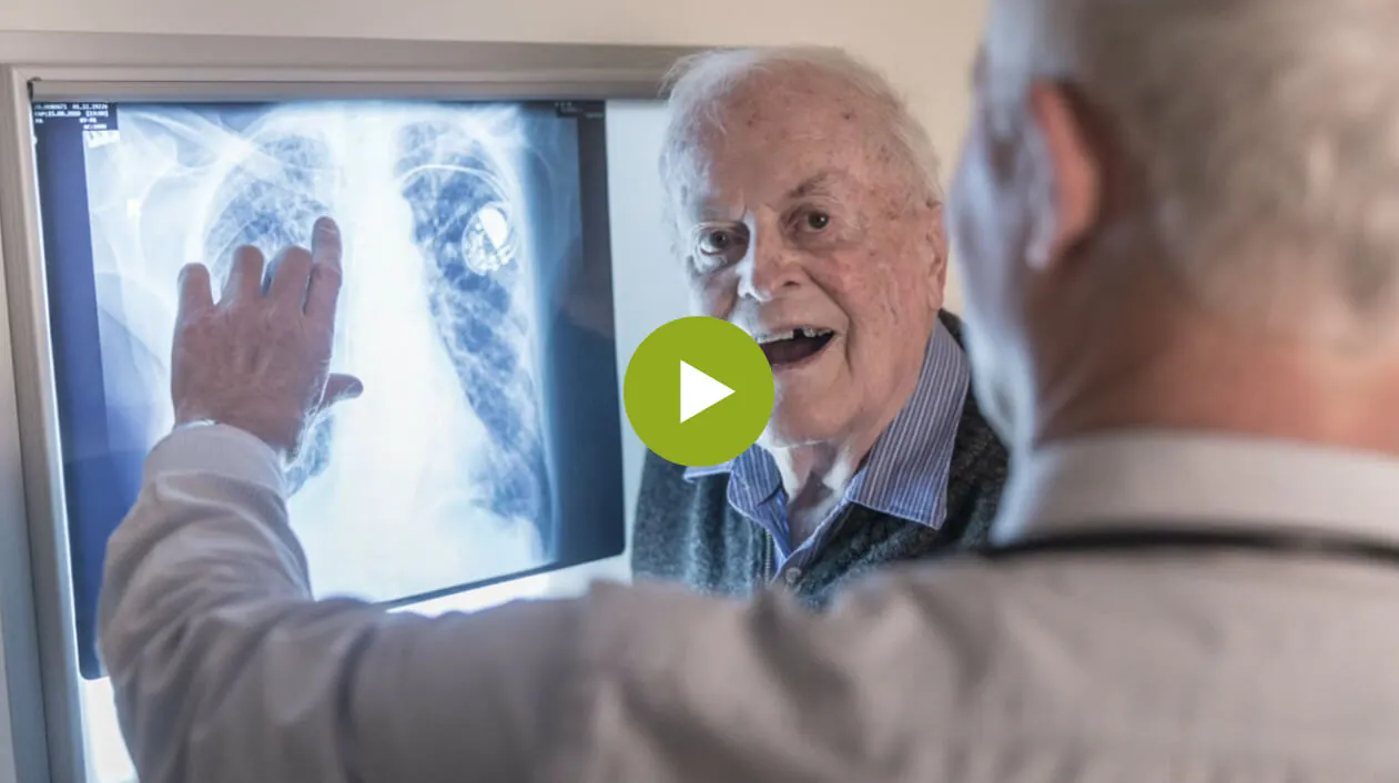 A clinician and a patient reviewing scan images on a screen together