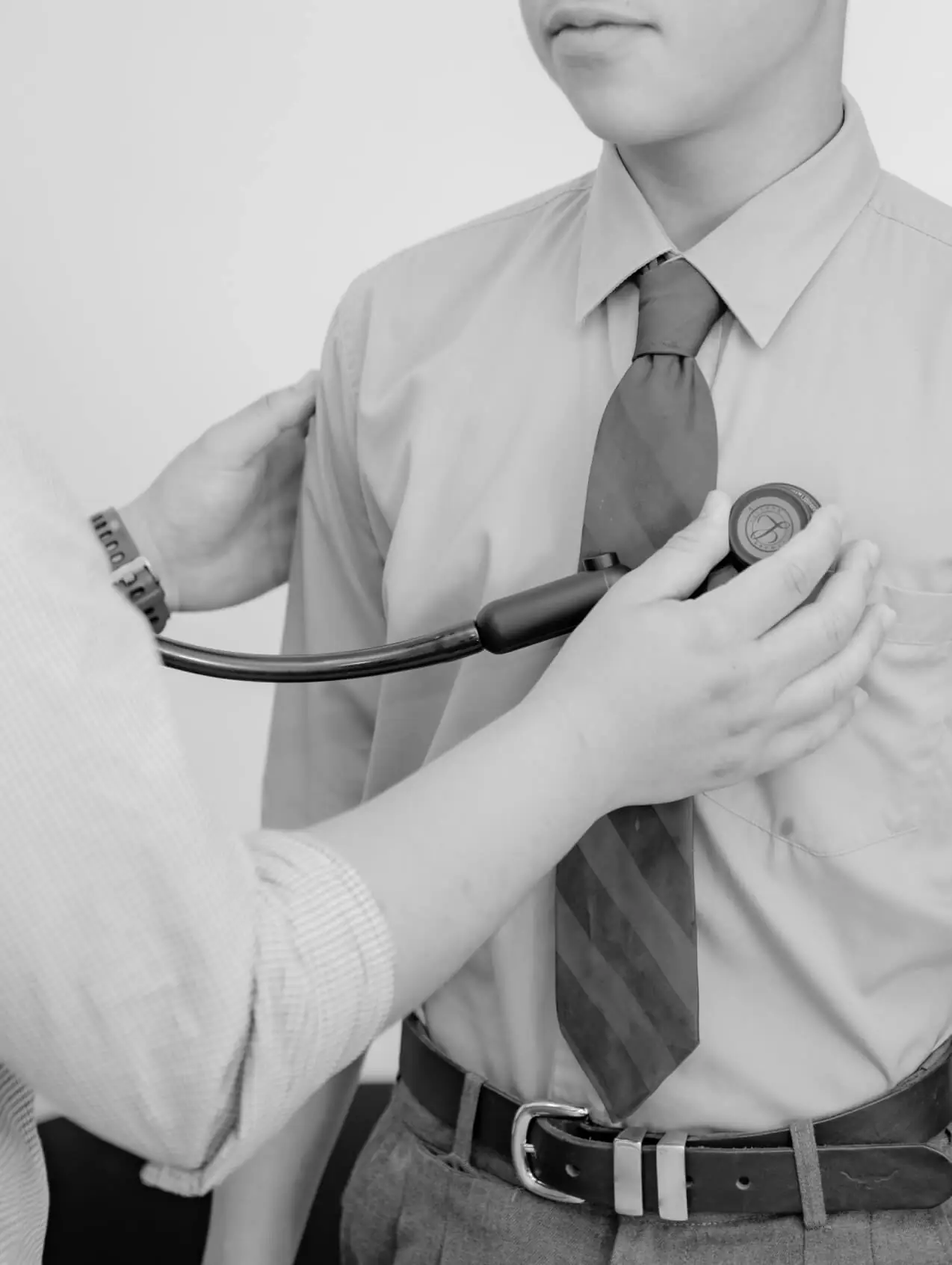 A doctor listening to a patient's chest with a stethoscope